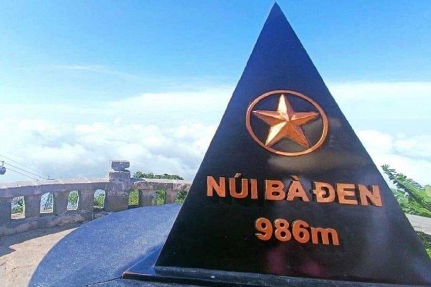Ein schwarzes, pyramidenförmiges Schild mit einem Stern-Logo und dem Text 'NUIBADEN 986m', der eine Höhe von 986 Metern angibt. 3