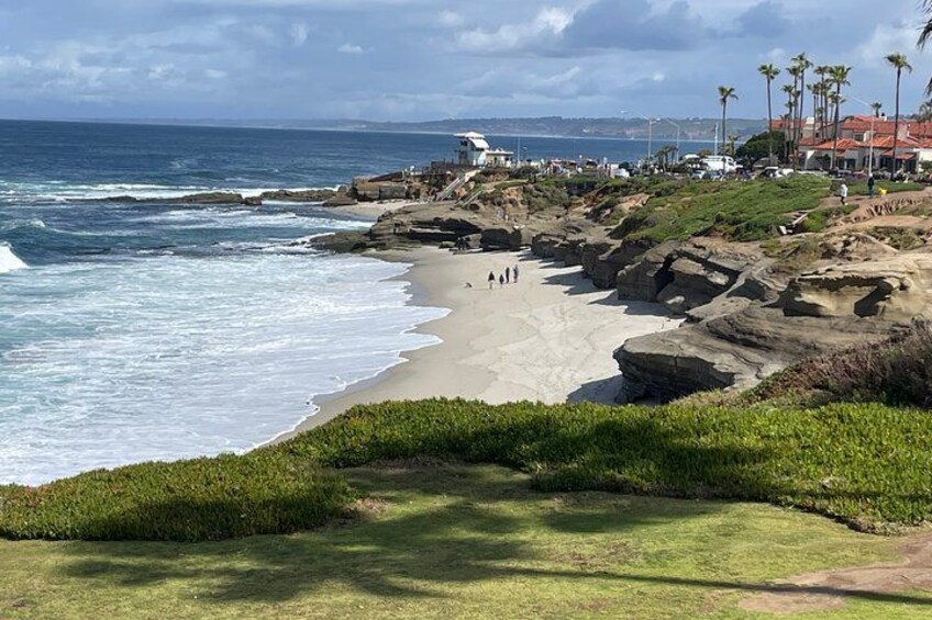 Paisaje costero con una playa arenosa, afloramientos rocosos y una vista despejada del océano. 2