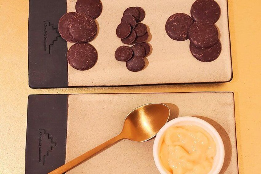 Una barra de chocolate con diseño geométrico, una cuchara y un tazón de crema. 2