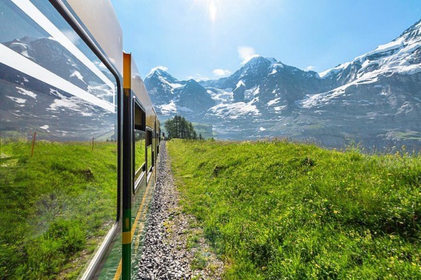 A train on tracks with a mountainous landscape in the background. 5