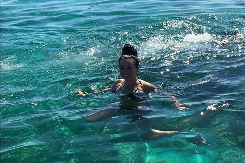 A person swimming in clear blue water. 2