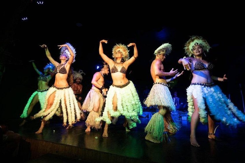 A group of dancers in traditional costumes performing on stage. 4