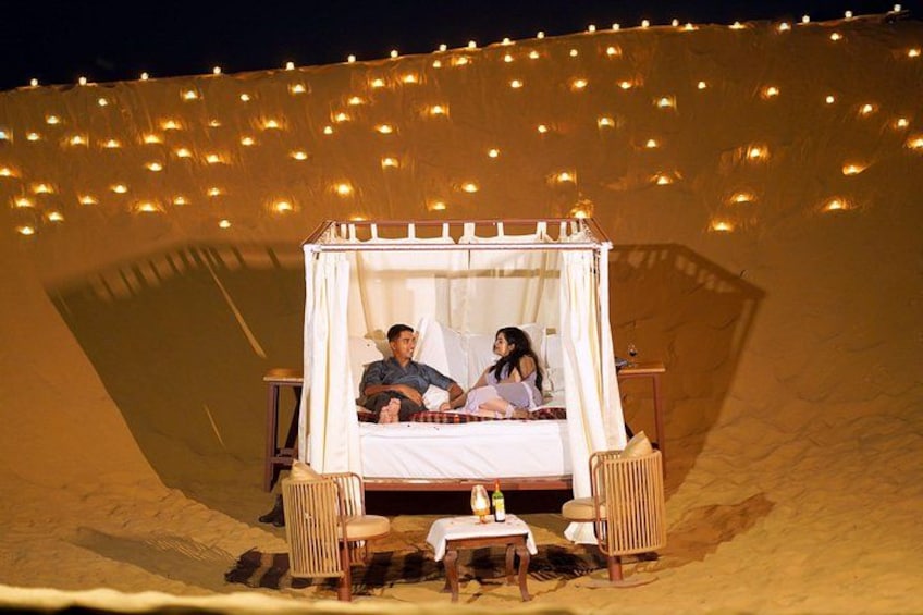 Een bed in een tent, verlicht met lichtslingers. 2