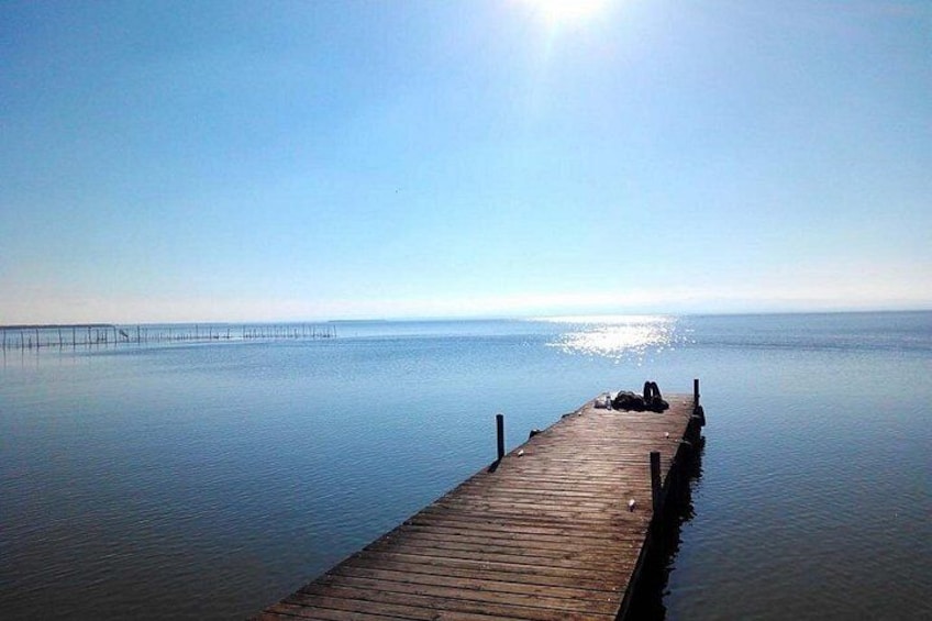 A wooden pier extending into calm water with a clear sky above. 5