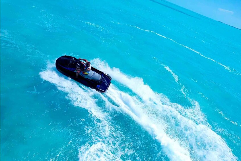A person jet skiing on turquoise water. 2