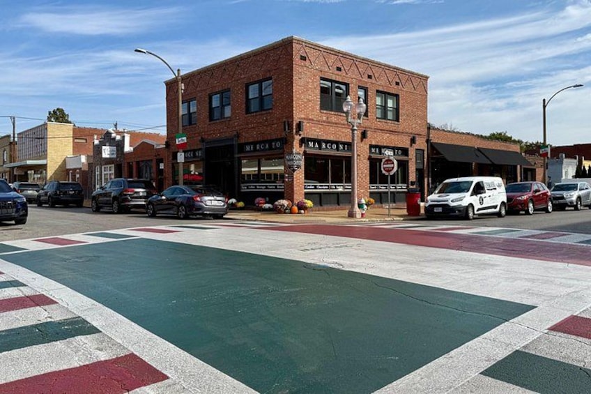 A street with a brick building, cars, and a crosswalk. 2