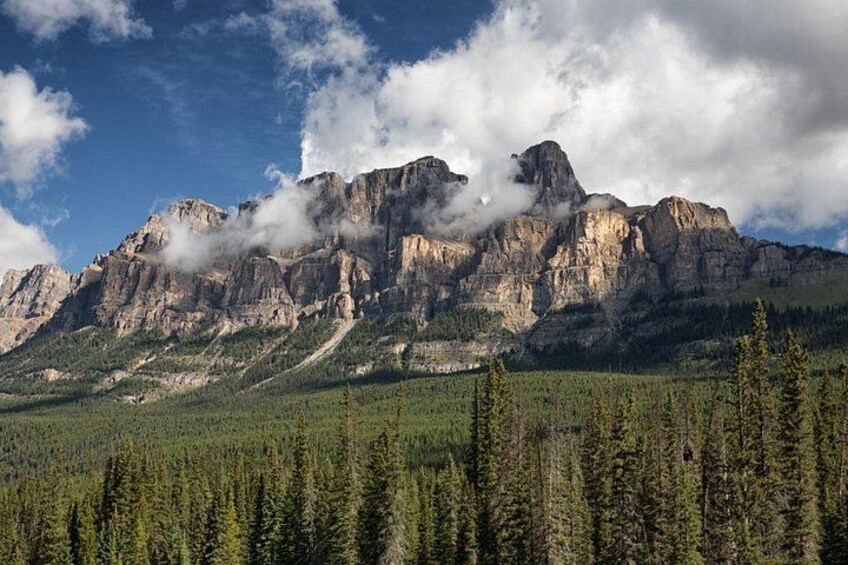 A mountain range with dense forests at its base. 1