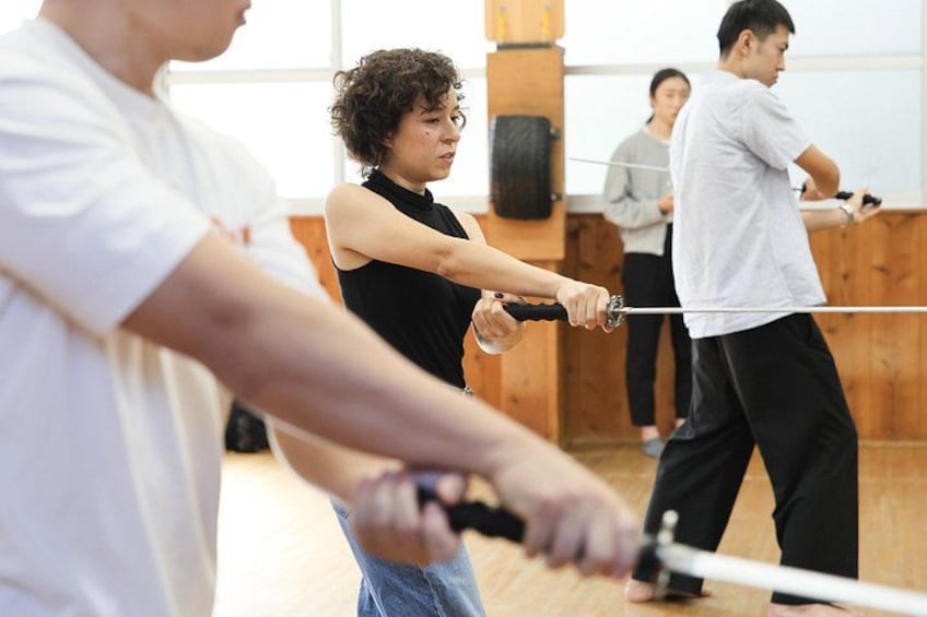 Personer som tränar svärdskonst i en dojo. 3