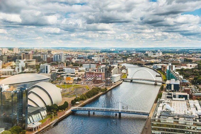 Un río con puentes, un estadio grande y un paisaje urbano con edificios y un puente a lo lejos. 1