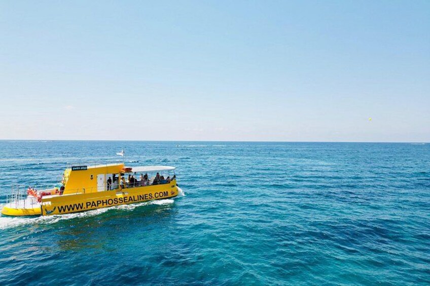 Un bote amarillo con la inscripción 'WWW.PAPHOSEALINES.COM' en su costado, flotando sobre aguas azules tranquilas. 2