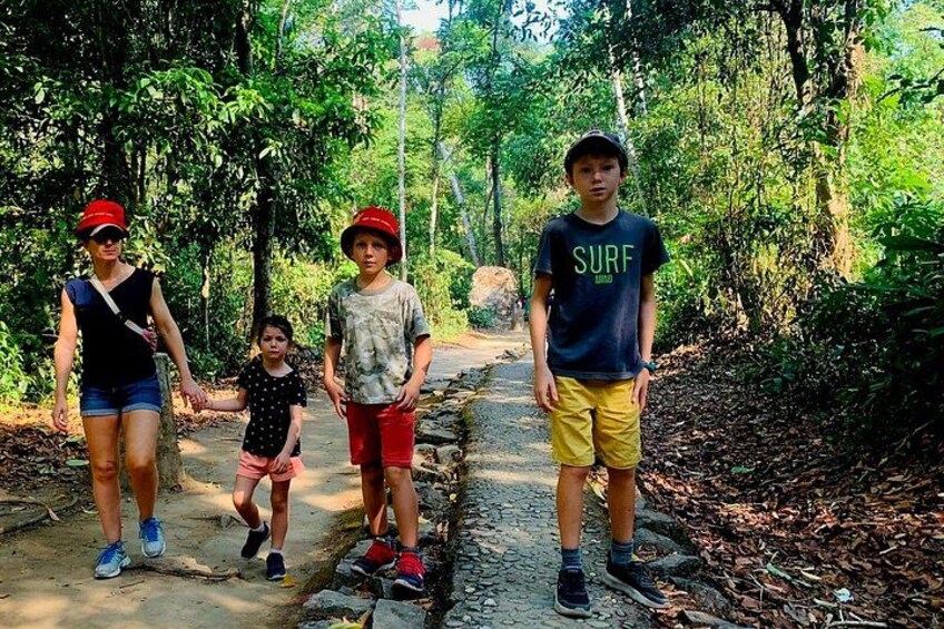 A group of people walking on a dirt path surrounded by trees. 3