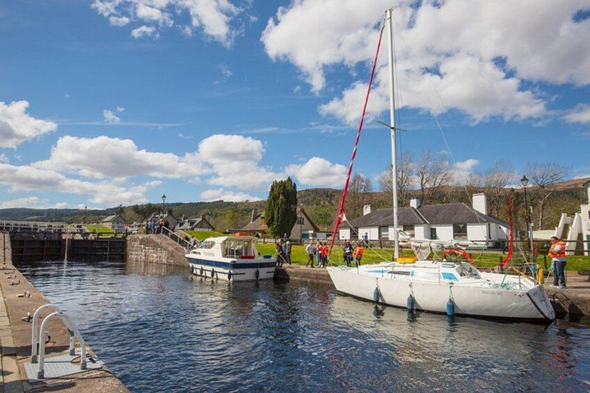 Un canal avec des bateaux, une écluse et des maisons en arrière-plan. 2