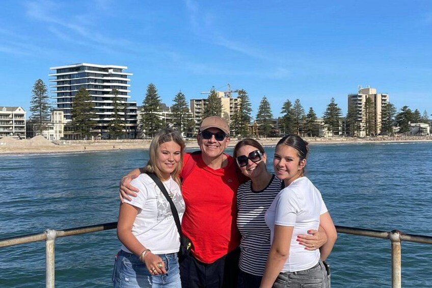 A group of people on a boat with a city skyline and water in the background. 3