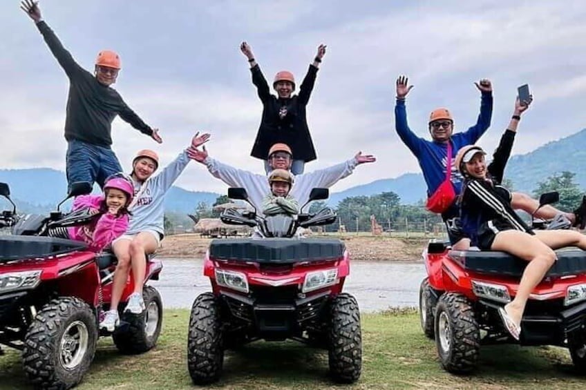 A group of people on ATVs with a lake and mountains in the background. 1