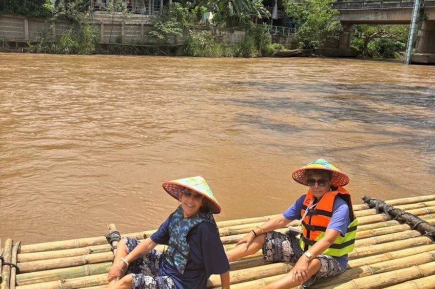 Two people in a bamboo raft on a muddy river. 2