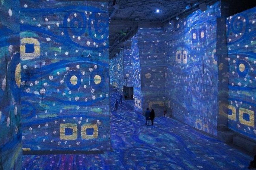 A room with large, illuminated wall murals featuring abstract patterns and shapes. 5