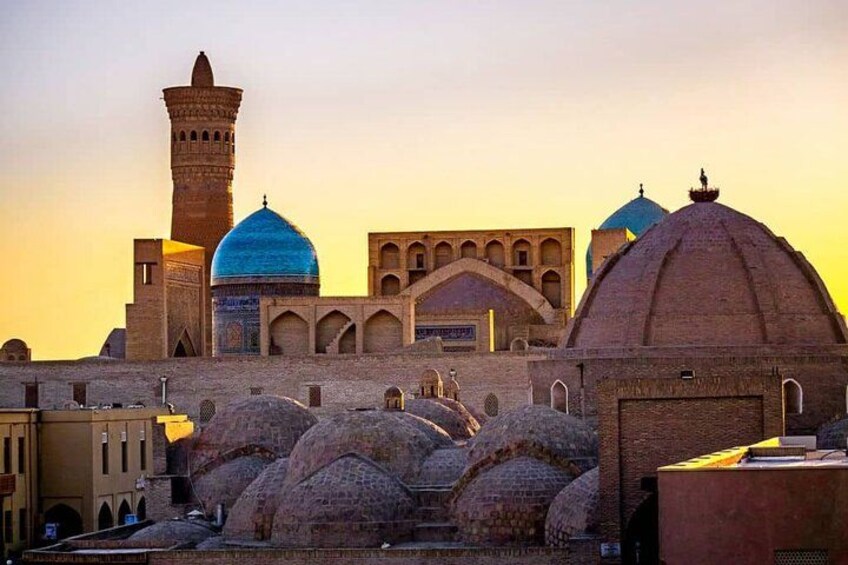 A historic building with domes and a minaret, likely a mosque, with a clear sky in the background. 2
