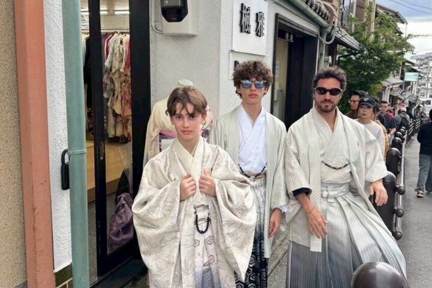Drei Personen in traditioneller japanischer Kleidung vor einem Laden mit einem Spiegel. 2
