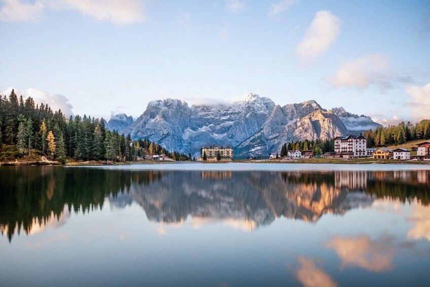 A calm lake reflecting mountains and buildings. 3