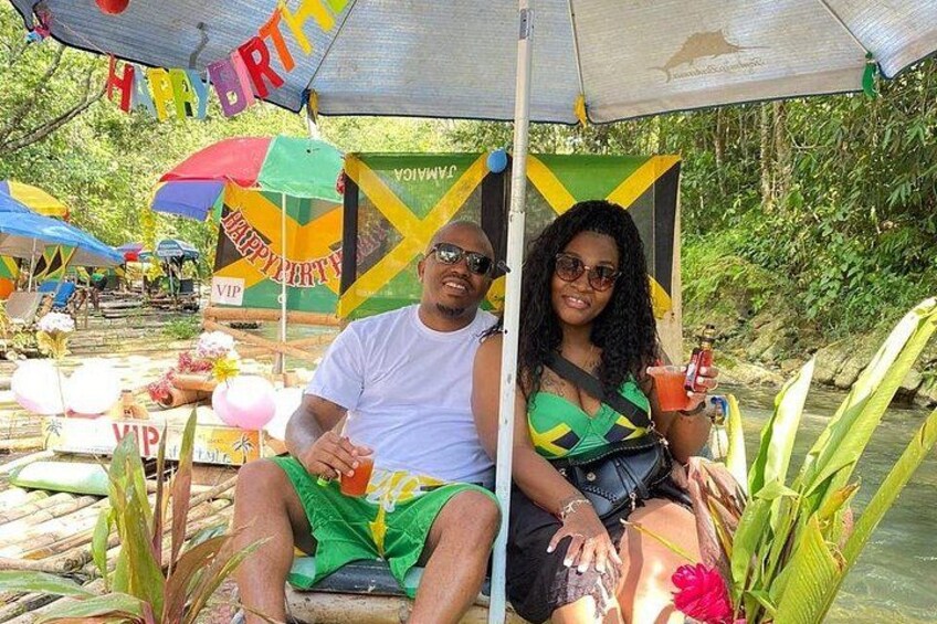 A couple on a boat with a 'Happy Birthday' banner, surrounded by greenery and water. 3