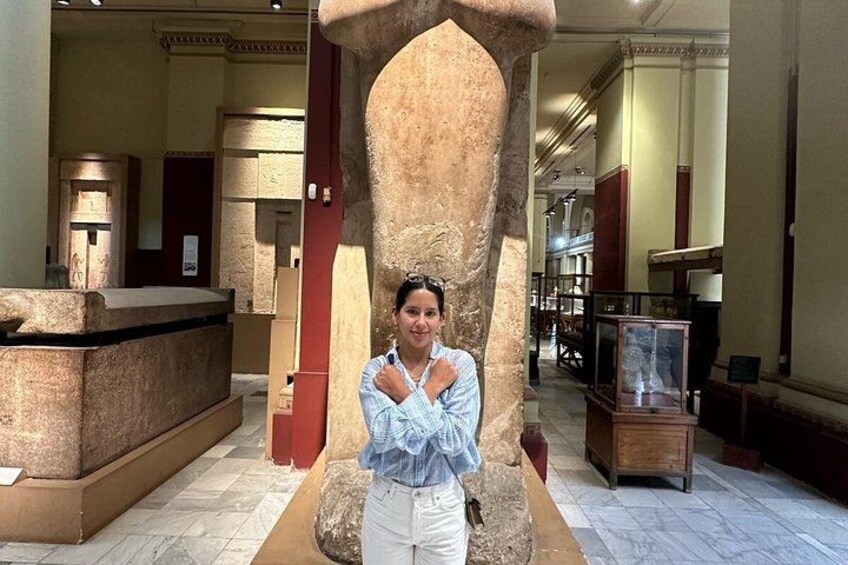 A person standing in front of a large stone structure in an indoor setting with marble flooring and classical architecture. 3