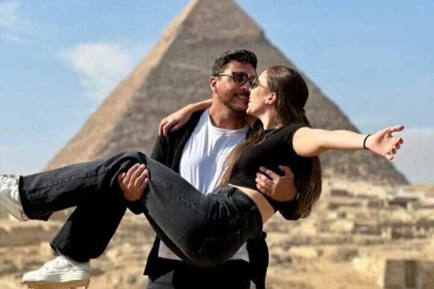 A couple embracing in front of a pyramid. 2