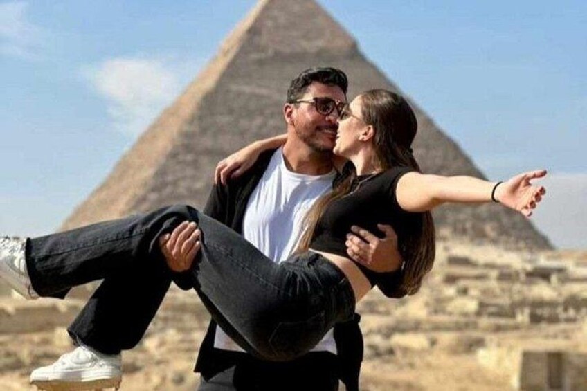 A couple embracing with a pyramid in the background. 2