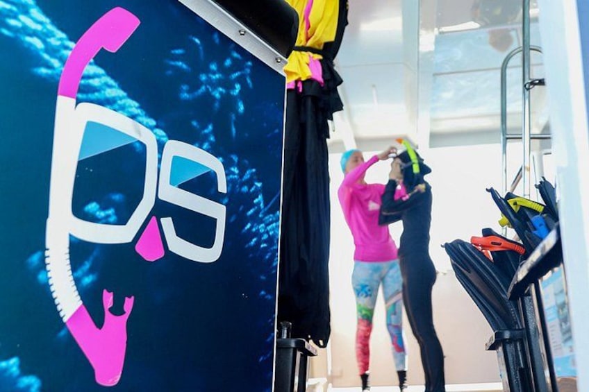 A person in a pink shirt working on a wall with a large '05' logo. 4