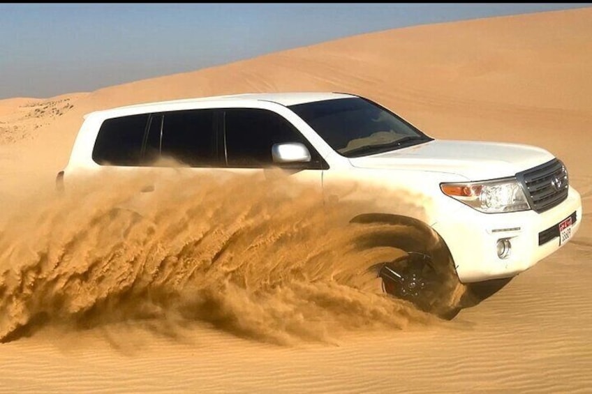A white SUV driving through a sandy desert. 3