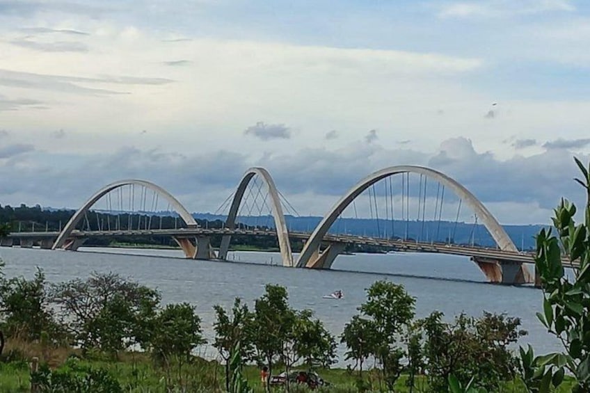 Eine Brücke mit zwei großen Bögen über einem Gewässer, umgeben von Grün. 2