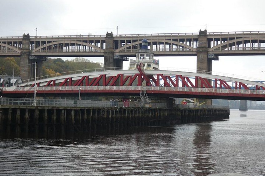 Un puente rojo sobre un cuerpo de agua con un barco amarrado al muelle. 2