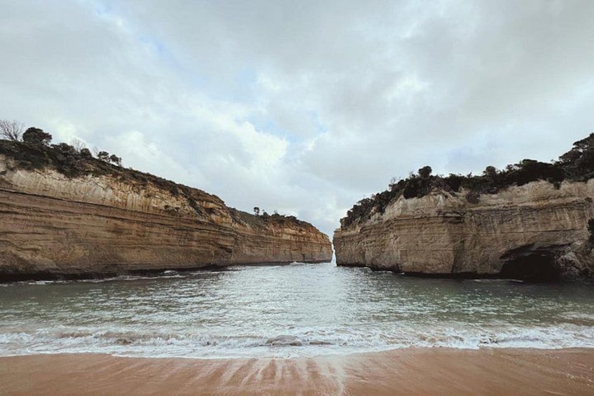 A coastal landscape with cliffs, a beach, and a calm sea. 3