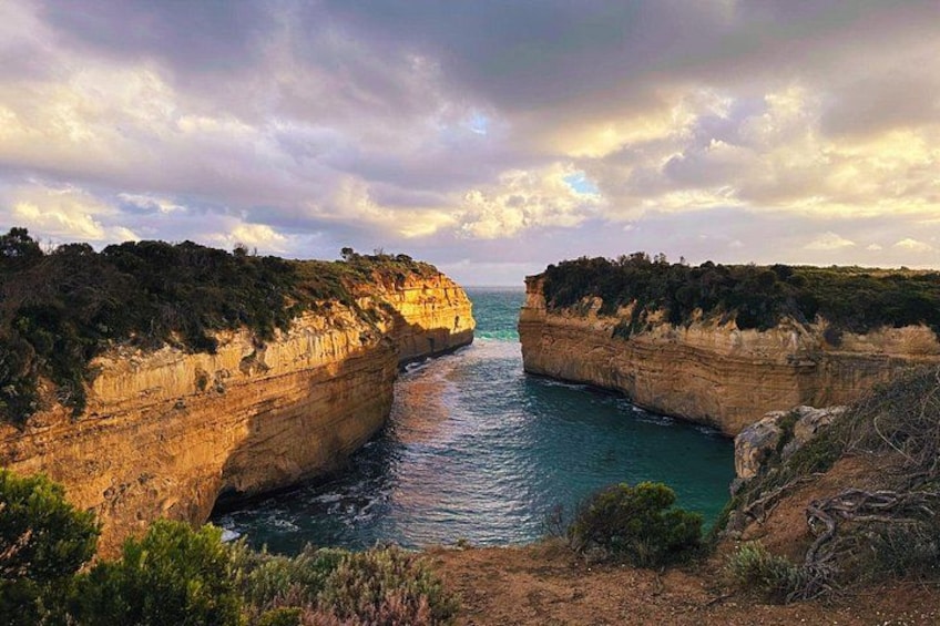 A coastal landscape with cliffs and a narrow waterway. 1