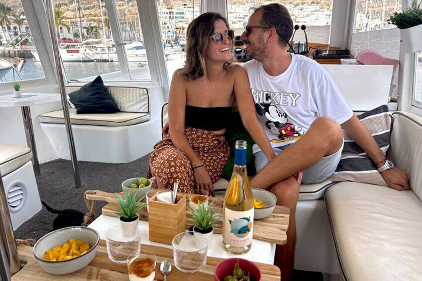 Una pareja sentada en un bote con una mesa frente a ellos. 3