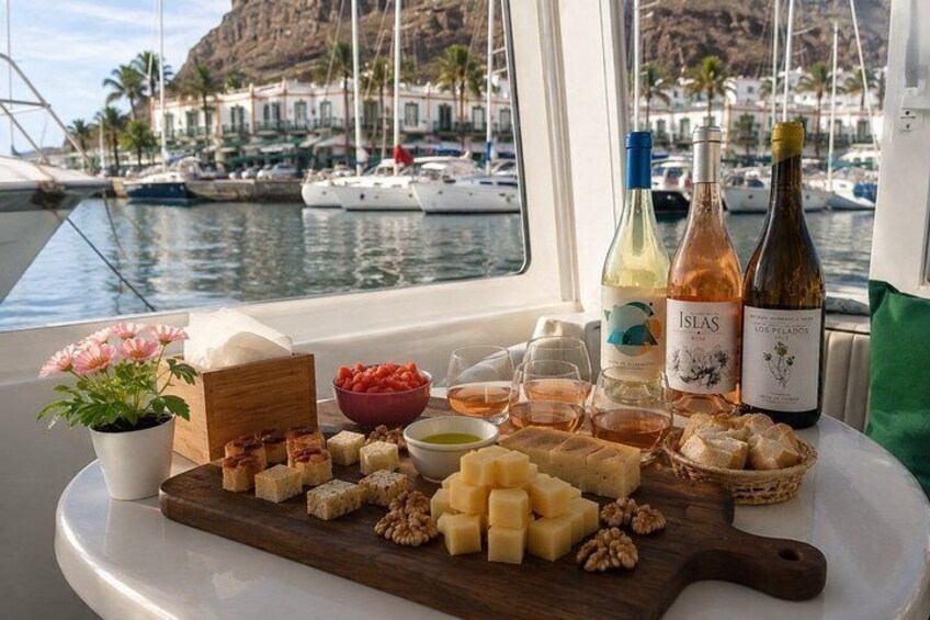 A boat with a table set with cheeses, nuts, and wine bottles. 1