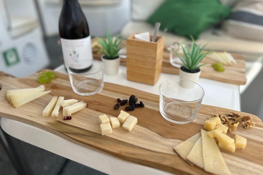 Una tabla de madera con queso, uvas y nueces. 2