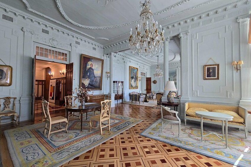 Une pièce somptueuse, ornée de lustres richement décorés, de colonnes classiques et d’un tapis à motifs. 2