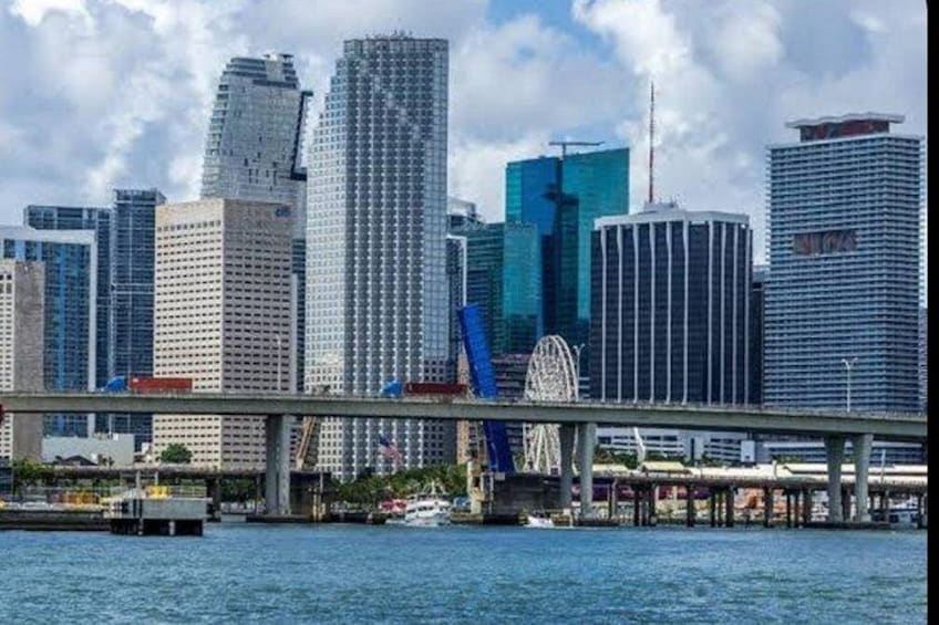 Un horizonte urbano con rascacielos modernos, un puente y una noria. 1
