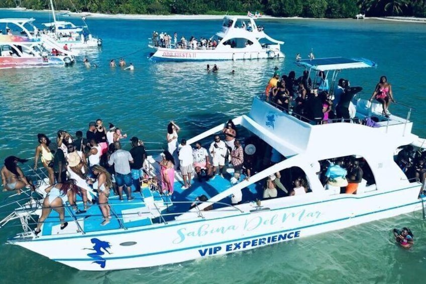 En båd ved navn 'Sabina Del Mar' med teksten 'VIP EXPERIENCE', fyldt med mennesker, der nyder vandet. 3