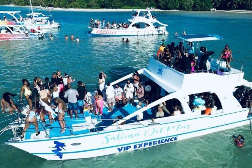 En båd ved navn 'Sabina Del Mar' med teksten 'VIP EXPERIENCE', fyldt med mennesker, der nyder vandet. 3
