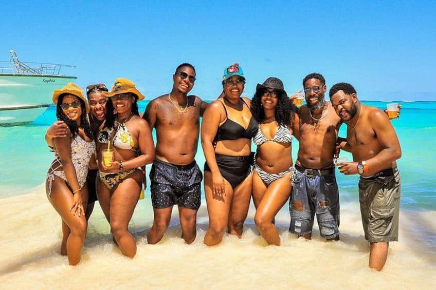 Un gruppo di persone su una spiaggia, con una barca sullo sfondo. 5