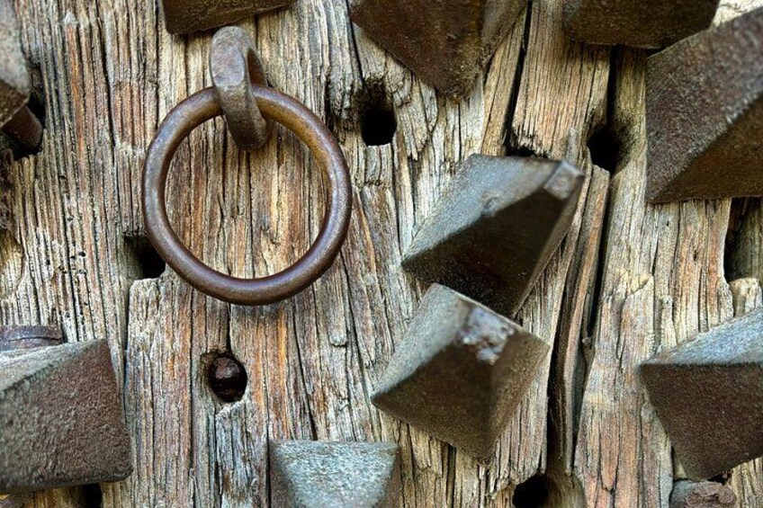 Un anillo de metal oxidado sobre una superficie de madera desgastada con púas metálicas sobresalientes. 5
