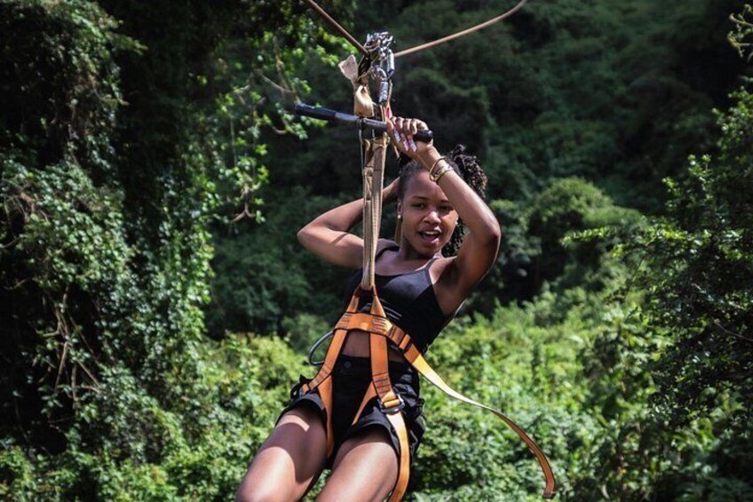 A person zip-lining through a forested area. 2