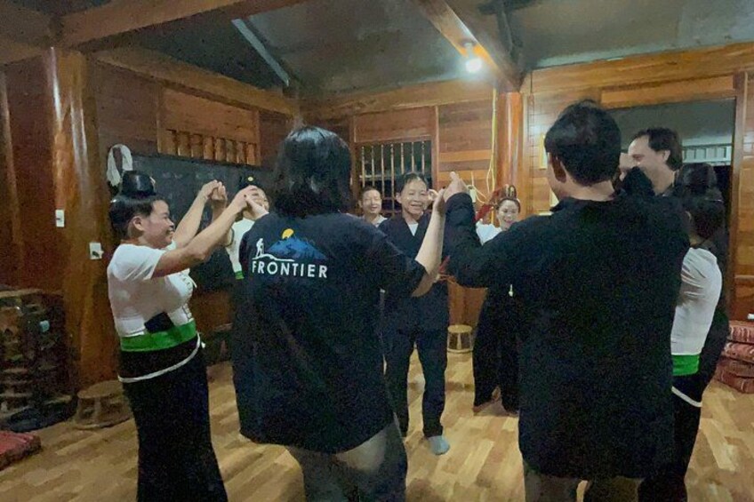 Een groep mensen danst in een houten kamer met een houten vloer. 1