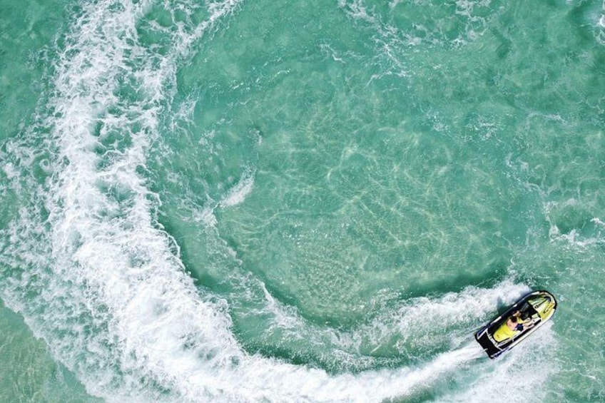 A boat on turquoise water with white foam waves. 2