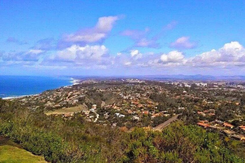 Un pueblo costero con vista al océano, casas y un paisaje montañoso. 2