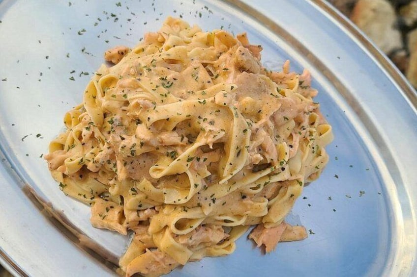 Un plato de pasta con salsa cremosa, adornado con hierbas. 2