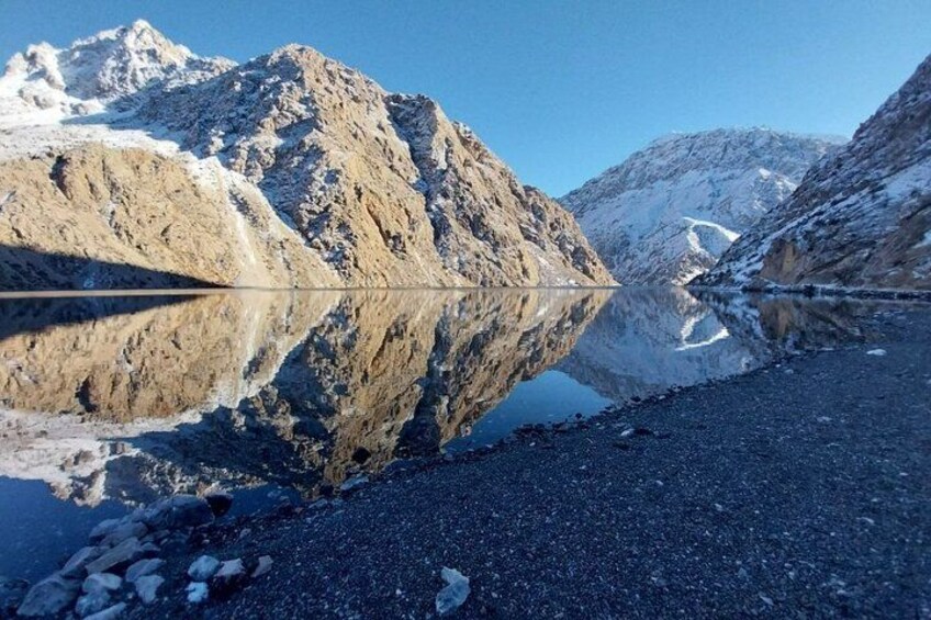 Una cordillera con un lago que refleja el paisaje. 1