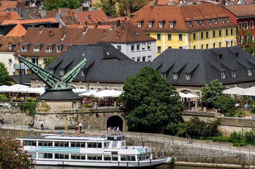 A river with a boat, a bridge, and buildings with red roofs. 2