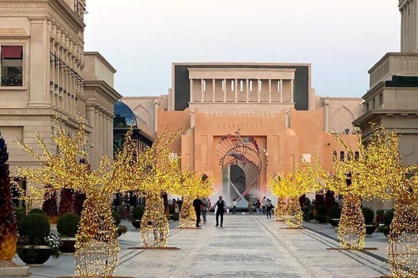 A grand entrance with illuminated trees and a large archway. 5